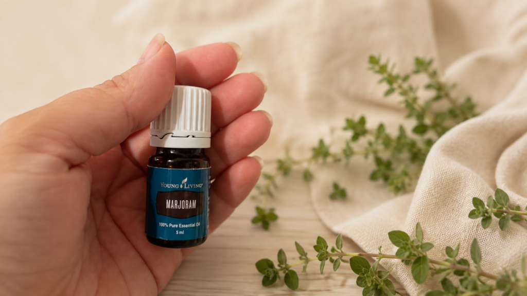Aceite esencial de mejorana junto a ramas frescas de mejorana.